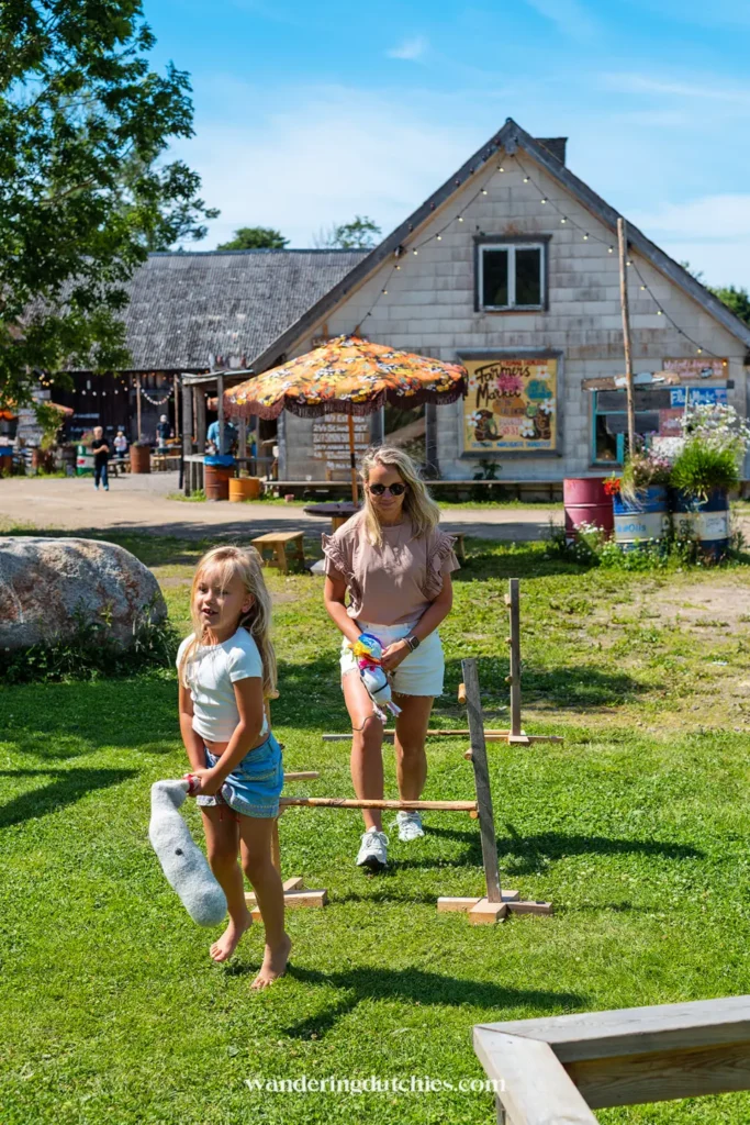 Moeder en dochter spelen buiten bij Strömma Farmlodge, met vintage aankleding en kleurrijke parasols.