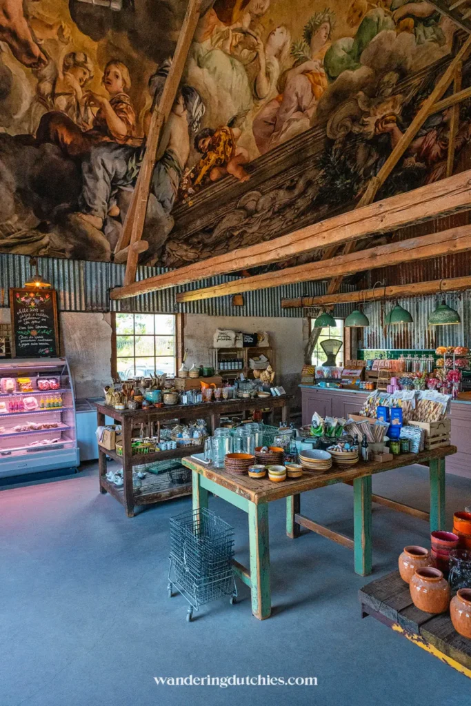 Binnen in de winkel van Strömma Farmlodge met lokale producten, servies en beschilderd plafond.