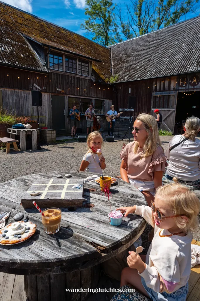 Gezin geniet van koffie, ijs en livemuziek op het terras van Strömma Farmlodge tijdens de zomer.