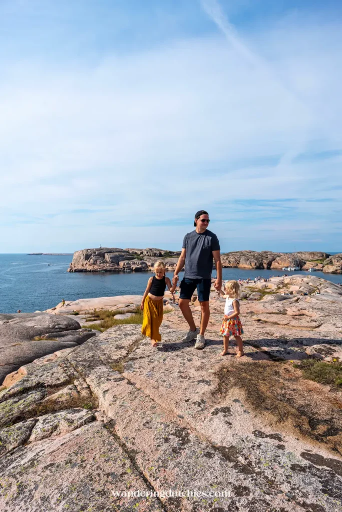 Gezin wandelt over de rotsen bij de kust van Smögen met uitzicht over zee.
