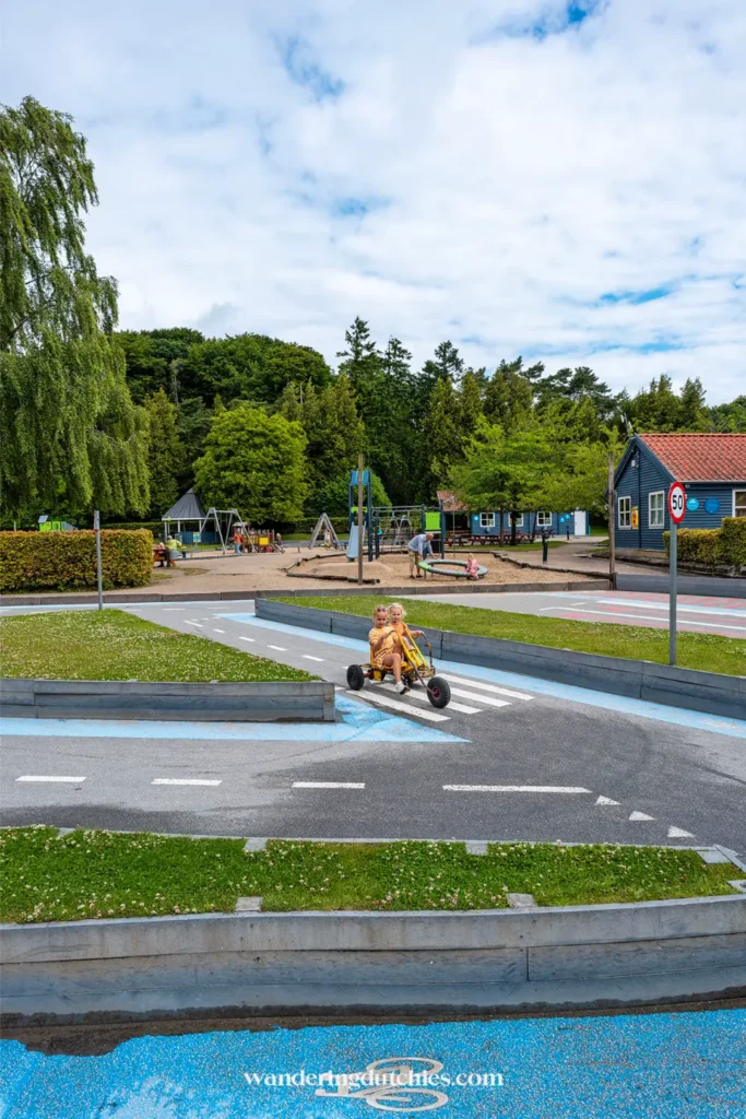 Kinderen rijden op een skelter over een verkeersplein in een speeltuin in Kolding, Denemarken