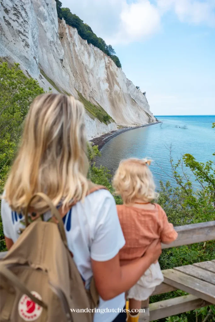 Moeder en kind kijken uit over de zee en de krijtrotsen van Møns Klint in Denemarken