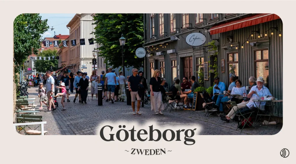 Drukke straat in Göteborg met mensen, terrasjes en de bekende Haga-borden