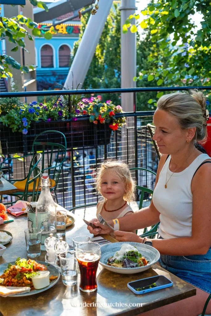 Moeder en kind eten samen op een terras in Gröna Lund in Stockholm tijdens een gezinsuitje