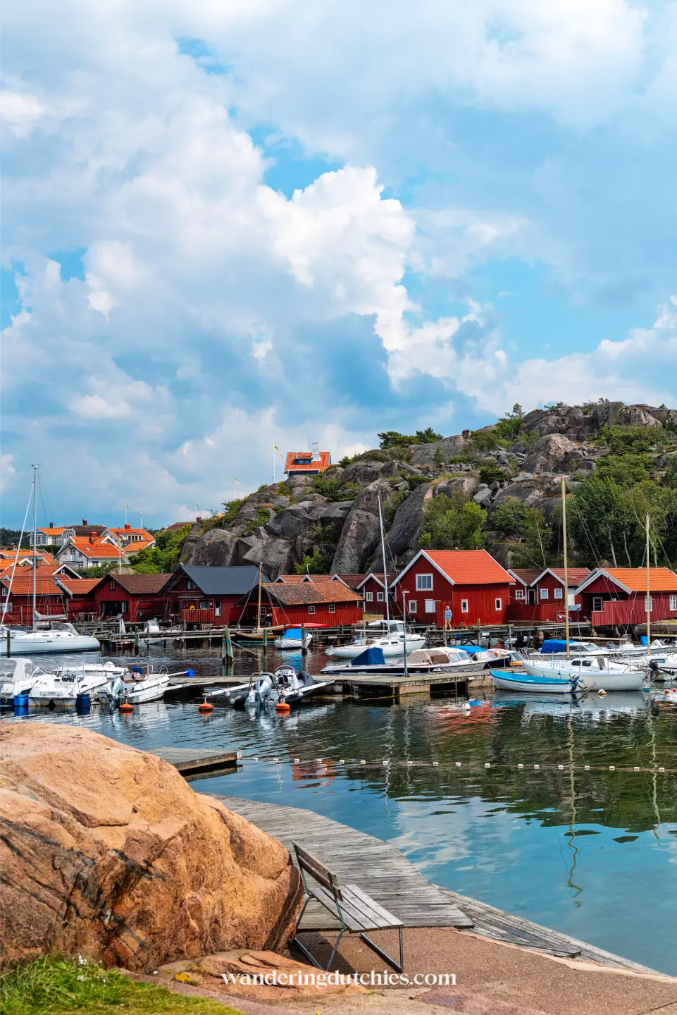 Rode vissershuisjes en boten in kleine haven aan de Zweedse westkust