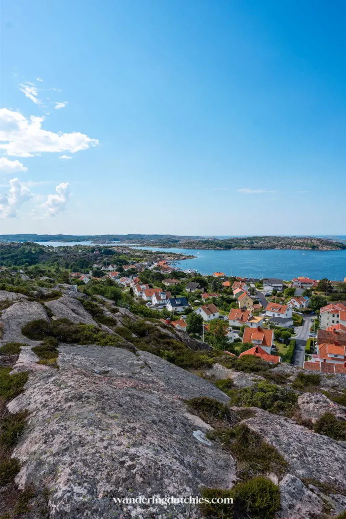 Uitzicht over dorp met rode daken en zee vanaf rotsen aan de westkust van Zweden