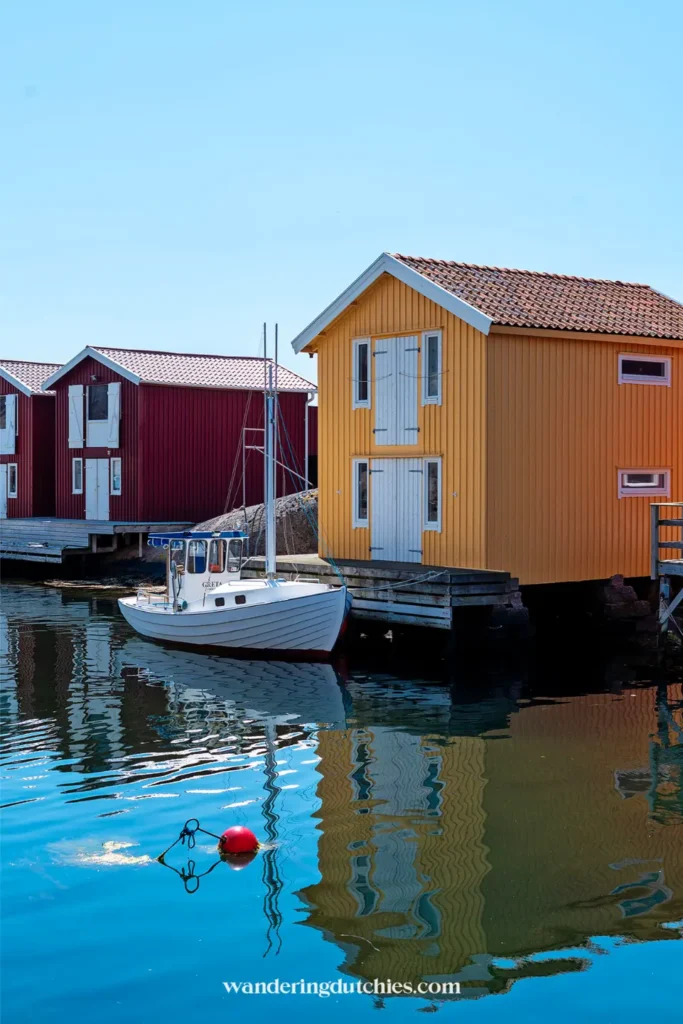 Geel boothuisje en boot in rustig water aan de Zweedse westkust