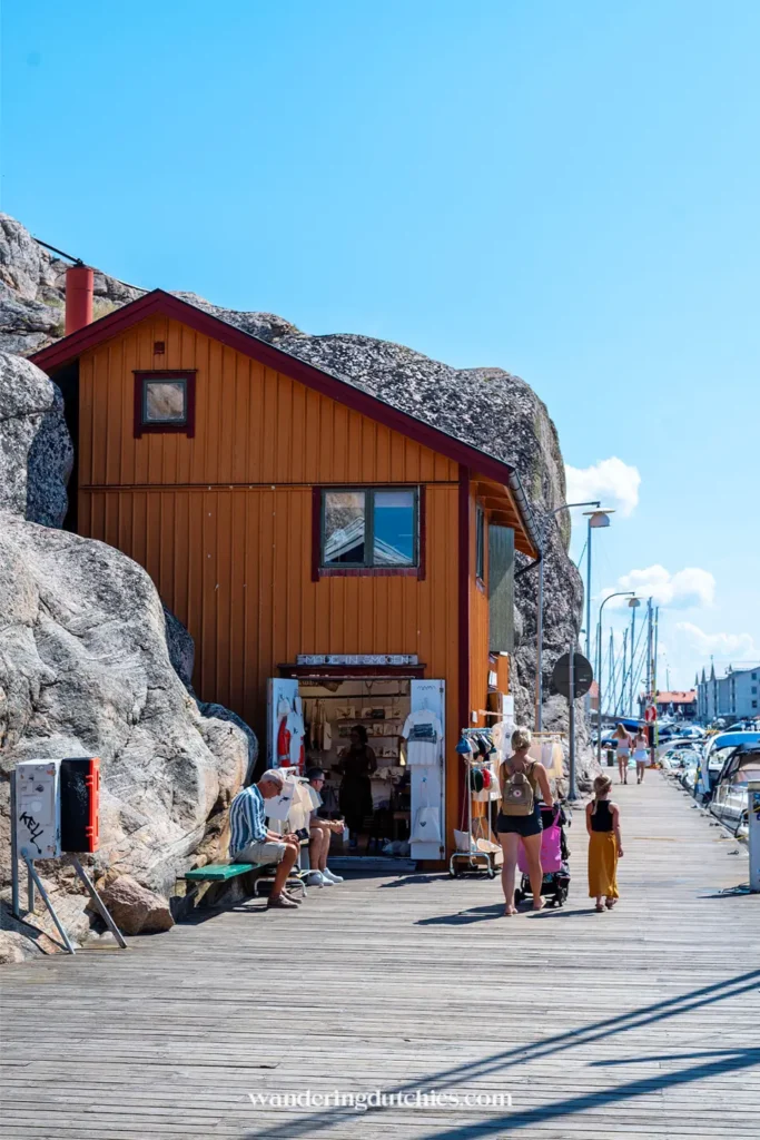 Houten huisje tegen rotsen langs boulevard van Smögen