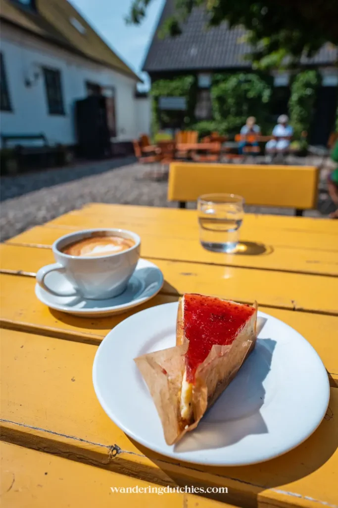 Koffie en taart op een gele tafel tijdens fika bij Olof Viktors in Zuid-Zweden
