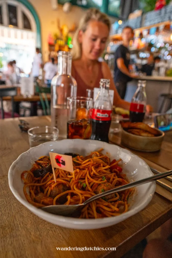 Bord met pasta in tomatensaus op tafel bij Meatballs for the People in Stockholm met drankjes ernaast