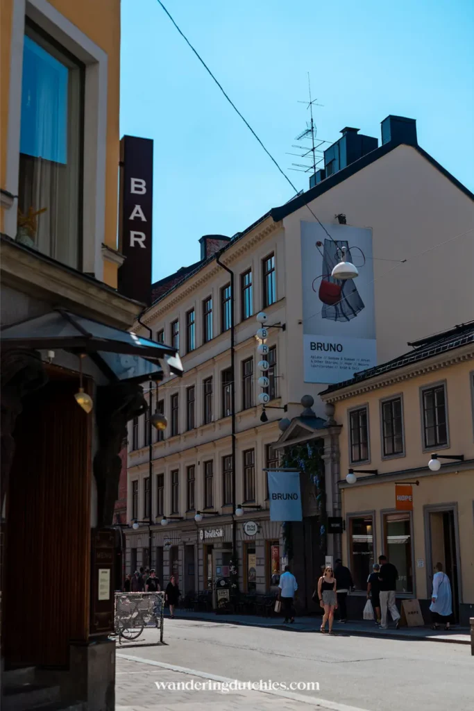 Straatbeeld in Stockholm met winkels, een barbord en het BRUNO uithangbord aan historische gevels