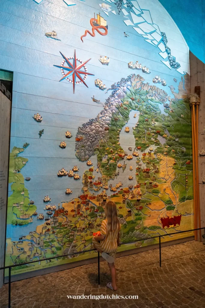 Kind kijkt naar een grote reliëfkaart van Scandinavië in een museum in Stockholm