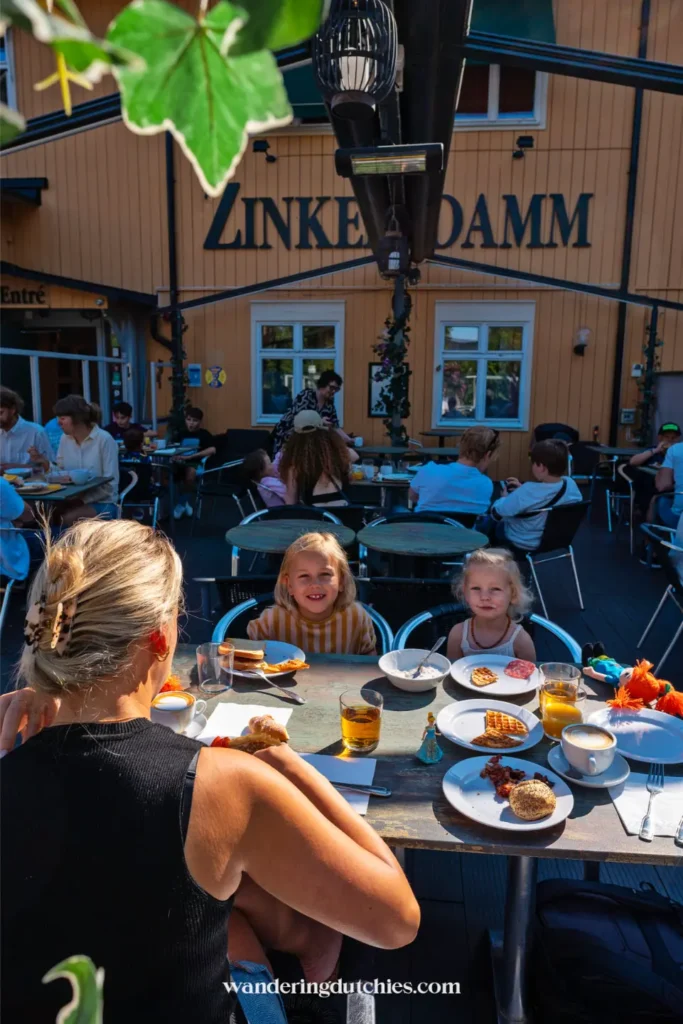 Gezin ontbijt op het terras van Zinkensdamm hostel in Stockholm met broodjes, wafel en sap op tafel