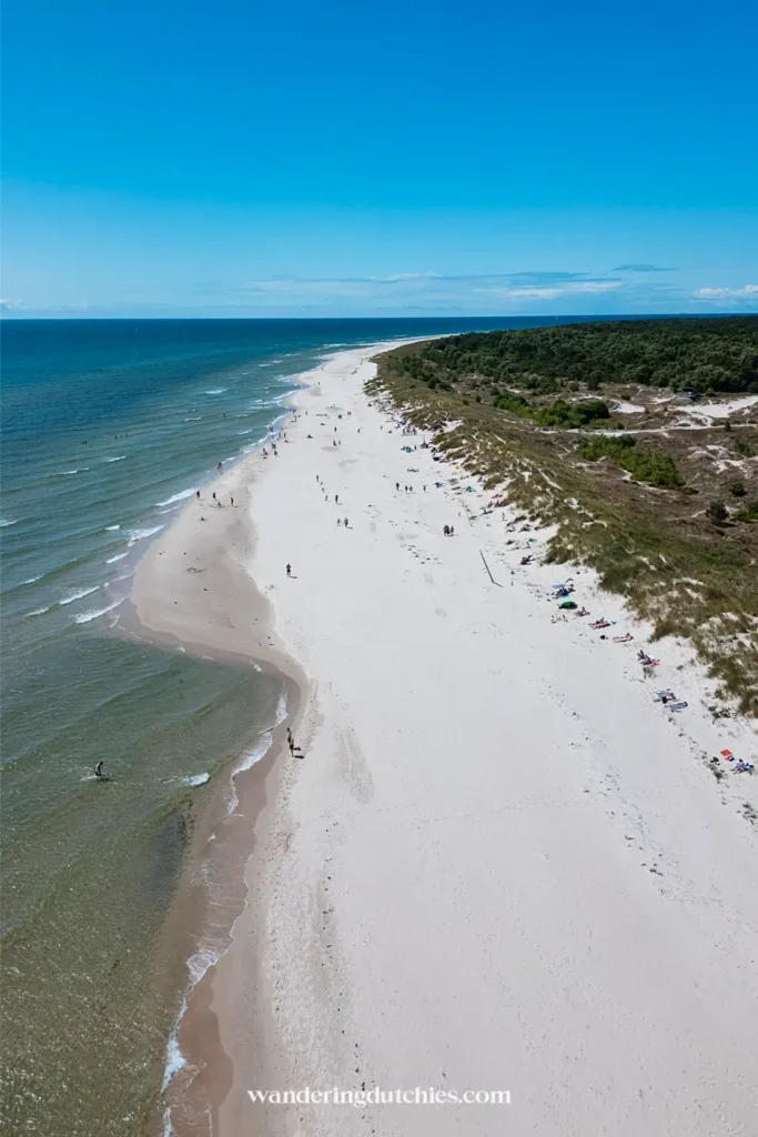 Breed wit zandstrand van Sandhammaren met duinen, zee en strandgangers gezien vanuit de lucht