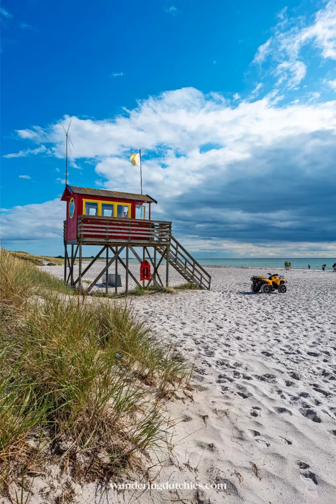 Rode en gele reddingspost op palen op het brede zandstrand van Skanör met zee op de achtergrond