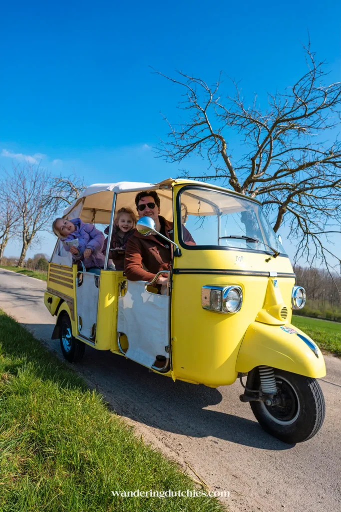 Gezin in een Ape Calessino tijdens de Bambinotour in Tongeren-Borgloon, leuke activiteit met kinderen in Belgisch Limburg.