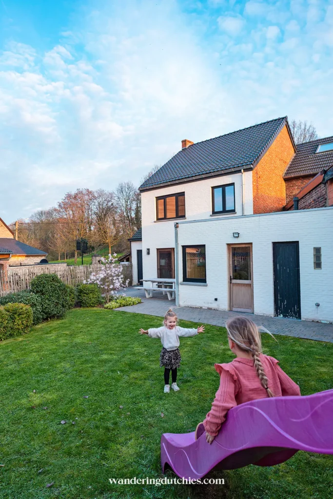 Kinderen spelen in tuin van vakantiehuis Spoor 23 met glijbaan in Borgloon, België.
