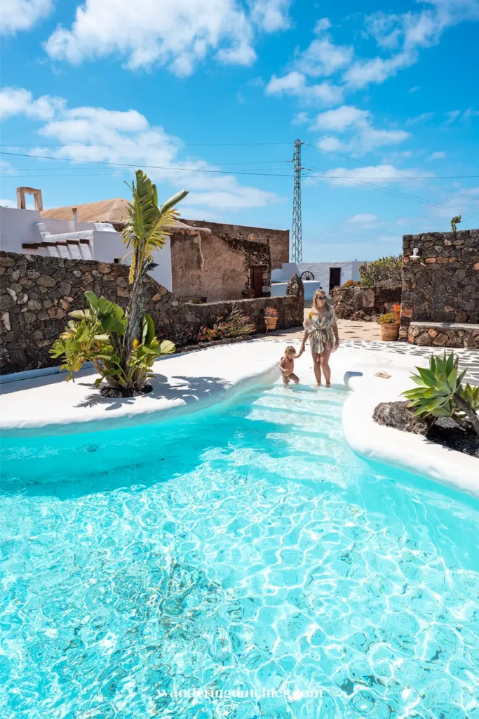 Moeder en kind spelen in zwembad bij finca op Lanzarote.