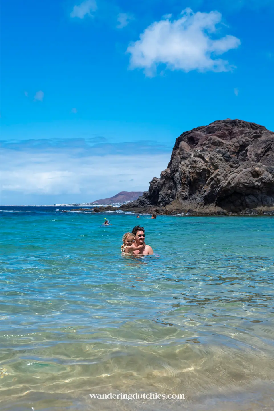Vader en kind zwemmen bij Playa de Papagayo op Lanzarote.