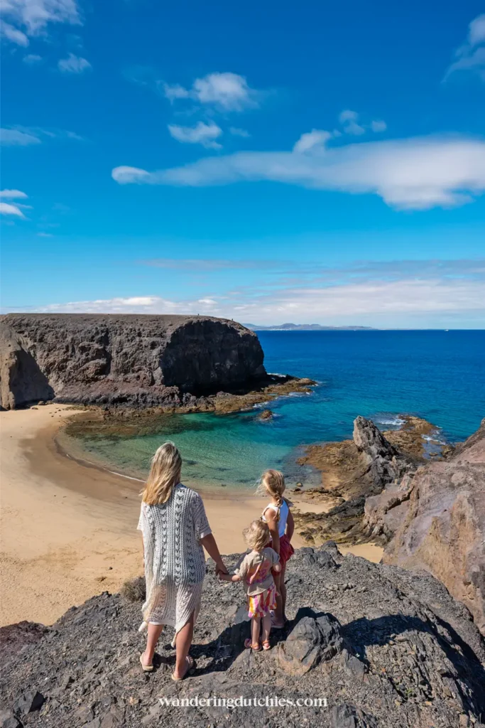 Gezin kijkt uit over Playa de Papagayo op Lanzarote.