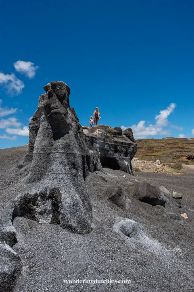 Moeder en kind bij rotsformaties van Stratified City op Lanzarote.