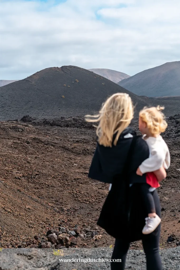 Moeder met kind in vulkanisch landschap van Timanfaya op Lanzarote.
