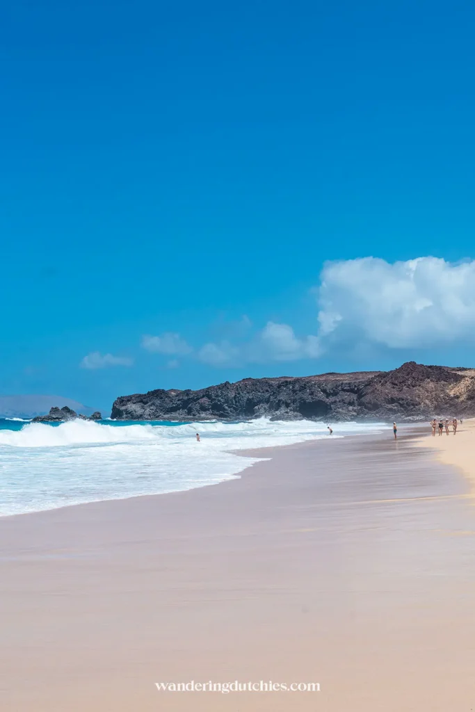 Rustig strand met golven en rotsen op La Graciosa bij Lanzarote.