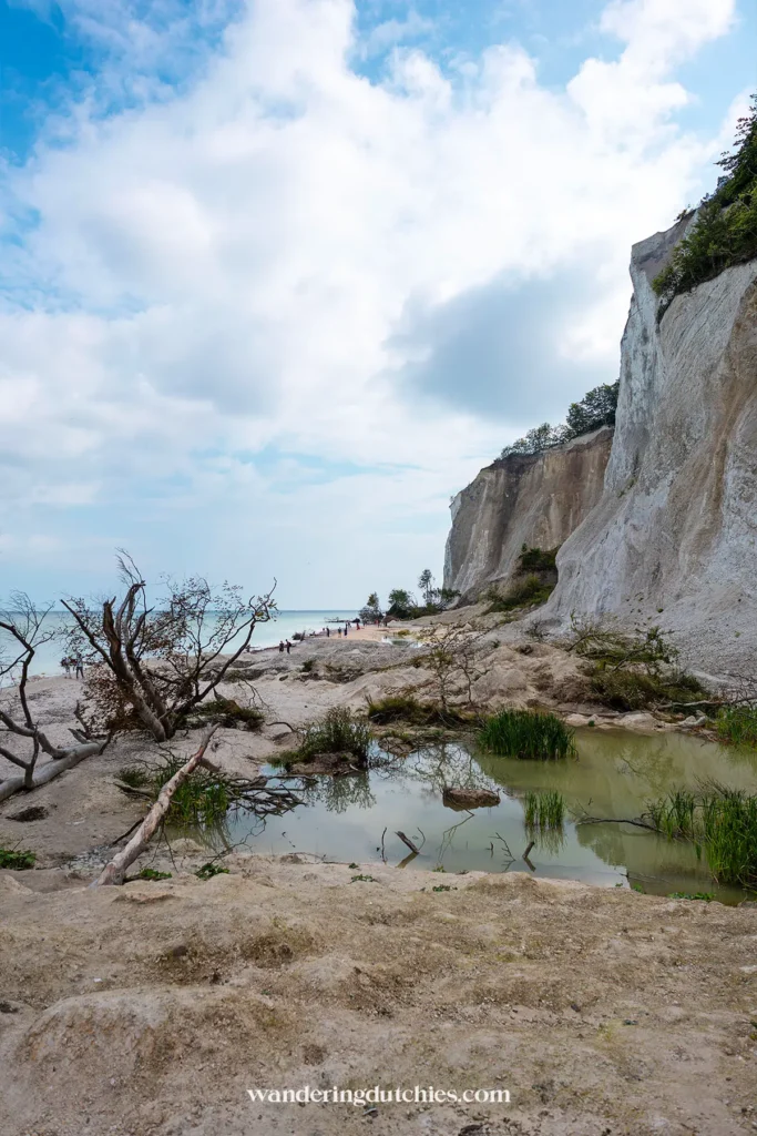 Strand onder de kliffen van Møns Klint met krijtrotsen en waterpoelen.