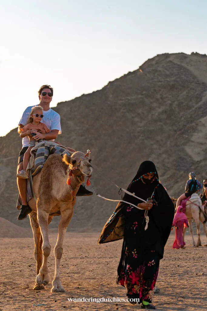 Vader en dochter op een kameel in de woestijn van Hurghada.