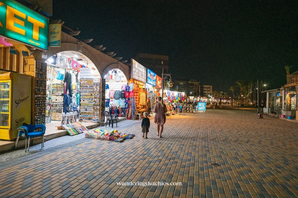 Verlichte straat met winkels en souvenirs tijdens een avondwandeling.