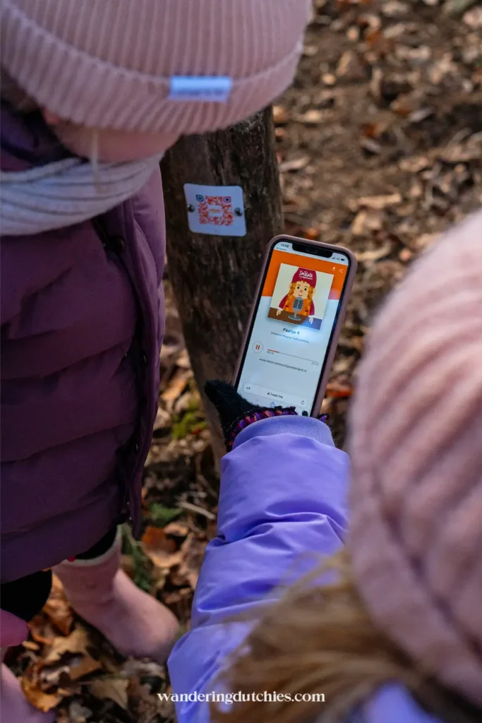 Children scanning a QR code with a smartphone during a gnome walk in Maria-Hoop, Limburg.