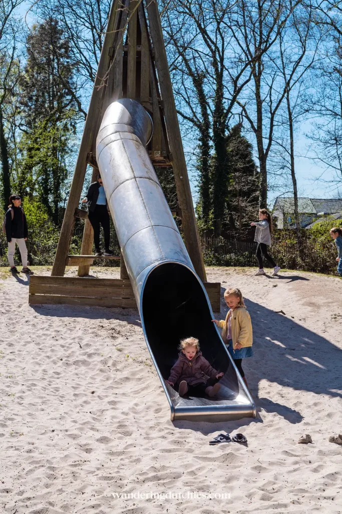 Children playing on a large slide at the playground near the Pietersheim Gnome Trail in Belgian Limburg.