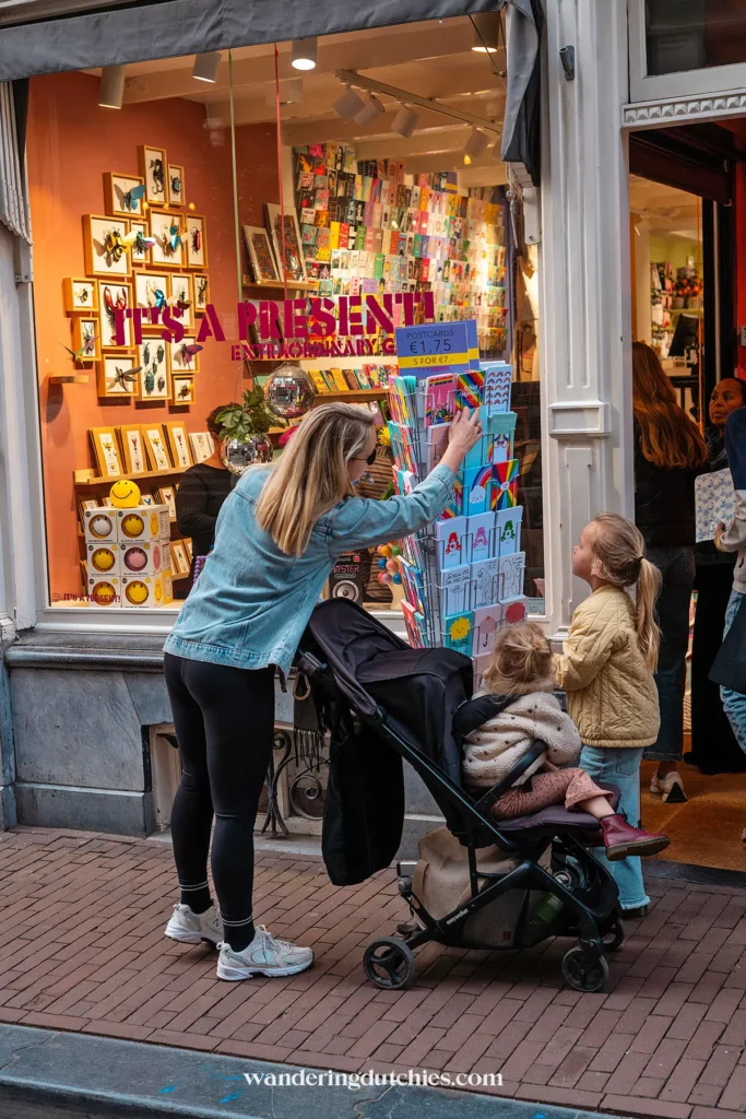 Mother and children browsing postcards in a shop in The Nine Streets in Amsterdam