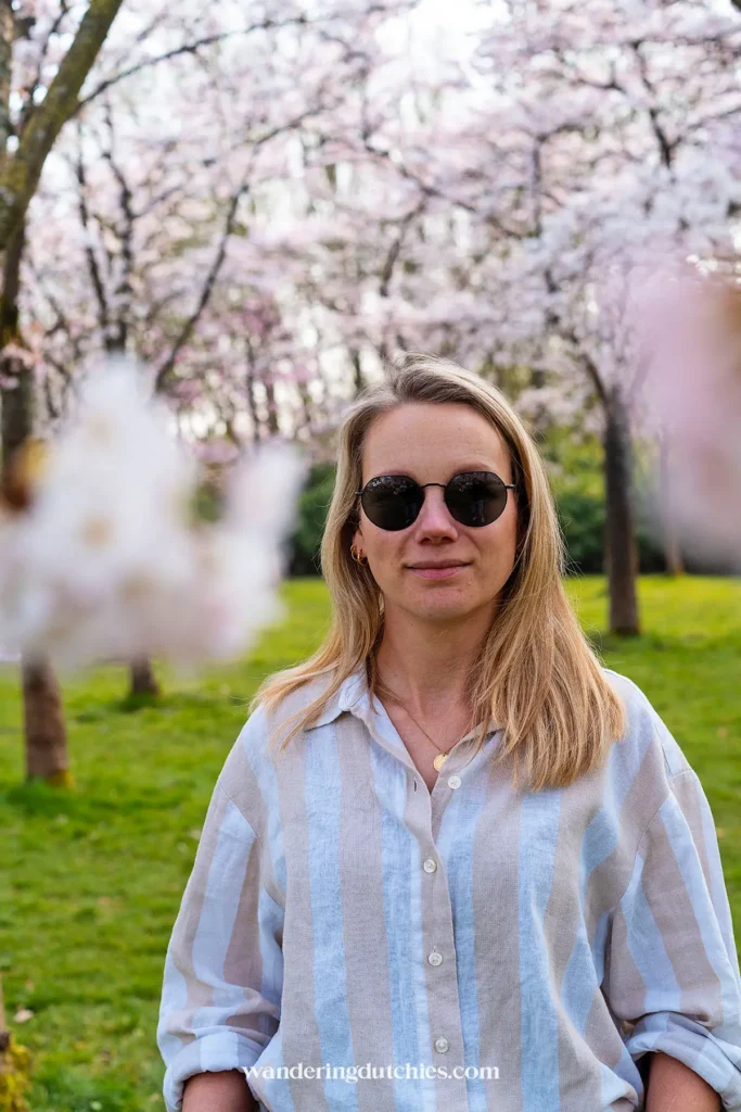 Woman standing among cherry blossom trees in Amsterdamse Bos