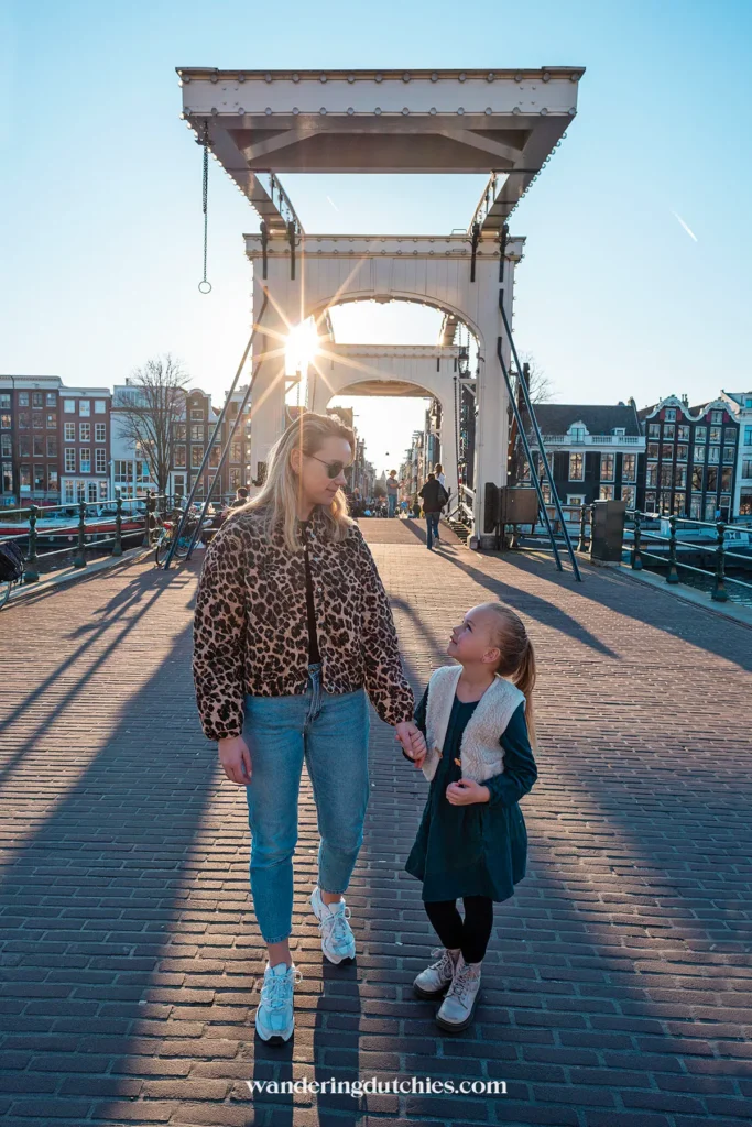 Mother and daughter walking across Magere Brug in Amsterdam