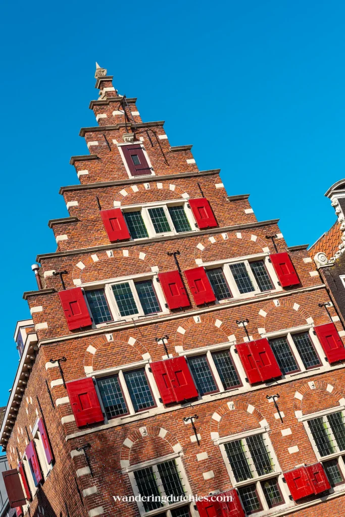 Historic canal house with red shutters in Amsterdam
