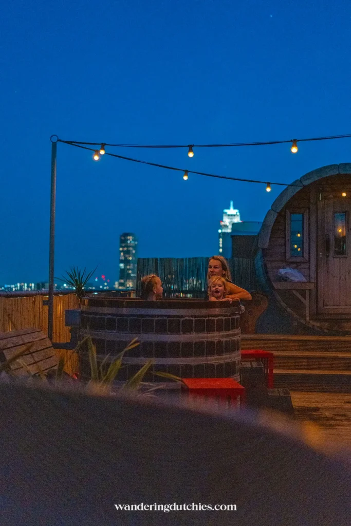 Mother and her children relaxing in a rooftop hot tub at Volkshotel Amsterdam