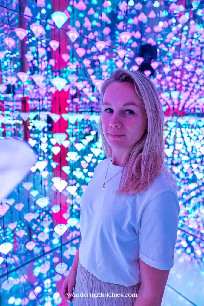 Woman in a colorful light installation at the Moco Museum in Amsterdam
