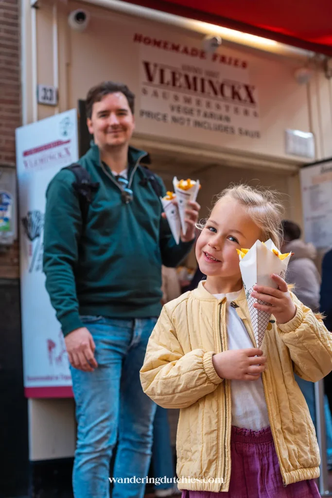 Father and daughter buying fresh Dutch fries in the center of Amsterdam