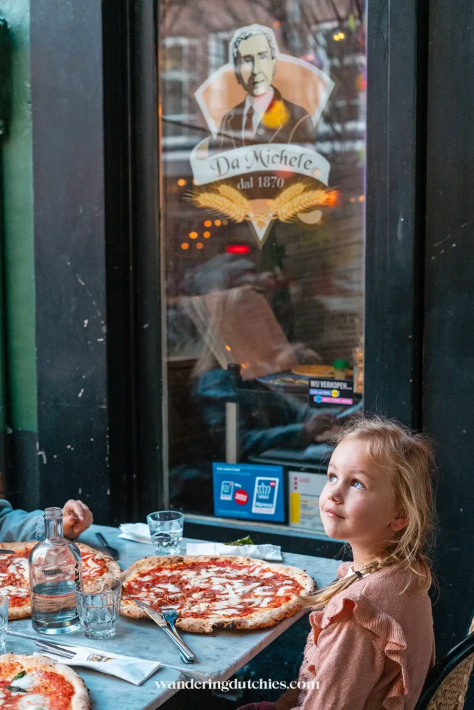 Child enjoying a pizza at Da Michele in Amsterdam