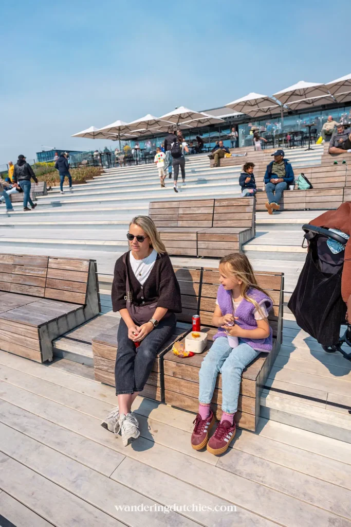 Moeder en dochter zitten op het mooie dakterras van NEMO Amsterdam