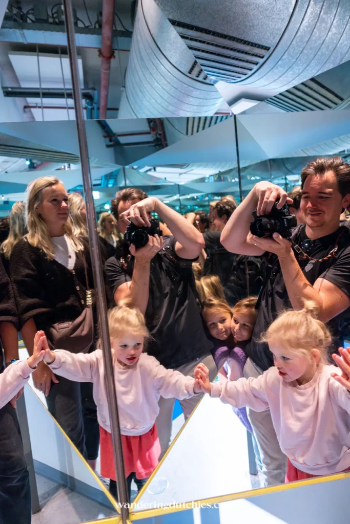 Het gezin ontdekt een spiegelinstallatie in NEMO Science Museum in Amsterdam