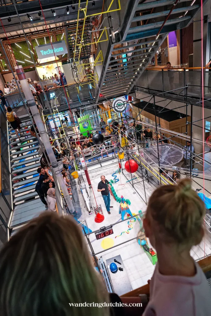 Moeder en dochter kijken naar de beroemde Kettingreactie in NEMO Science Museum in Amsterdam
