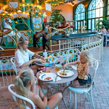 Gezin ontbijt naast de iconische draaimolen in Liseberg Grand Curiosa Hotel in Göteborg.