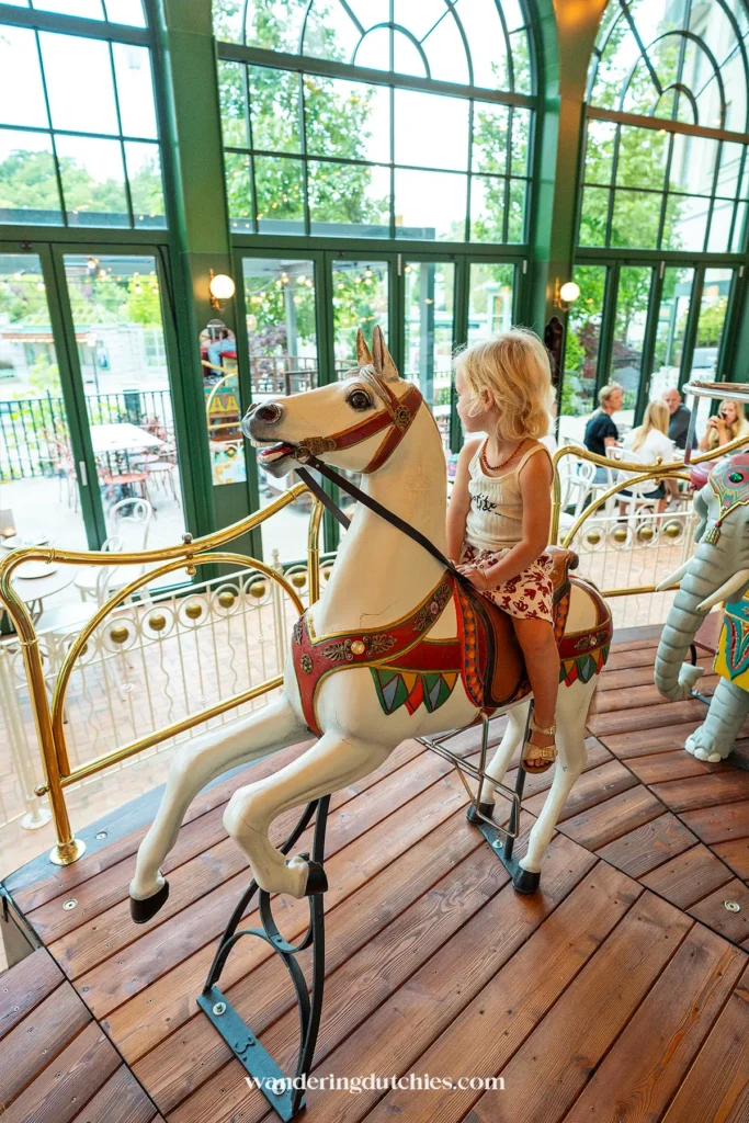 Peuter op de draaimolen in de serre van Liseberg Grand Curiosa Hotel in Göteborg.